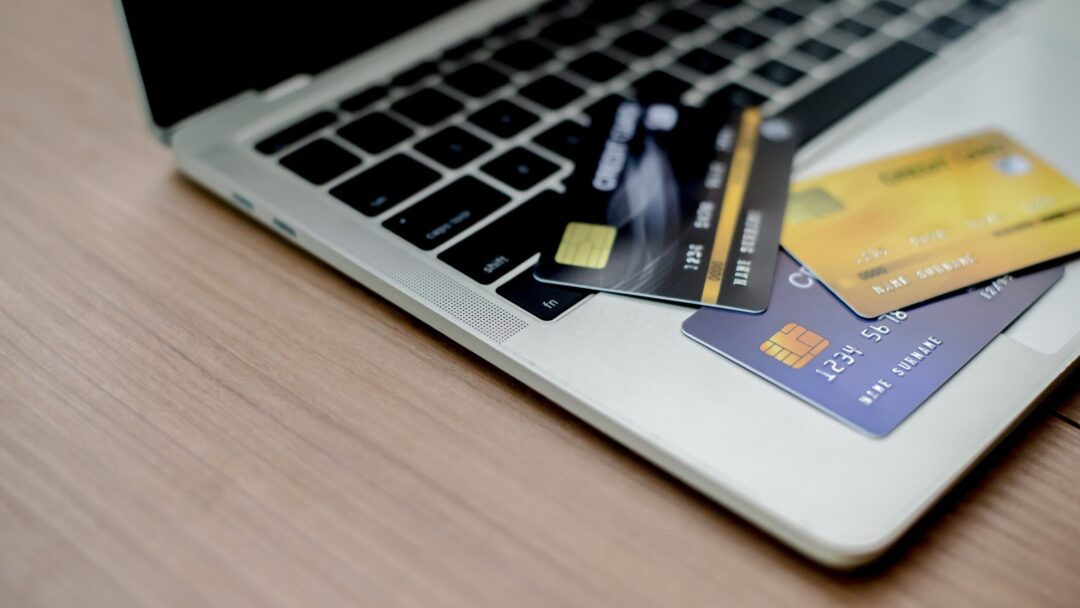 Multiple credit cards scattered on a laptop keyboard