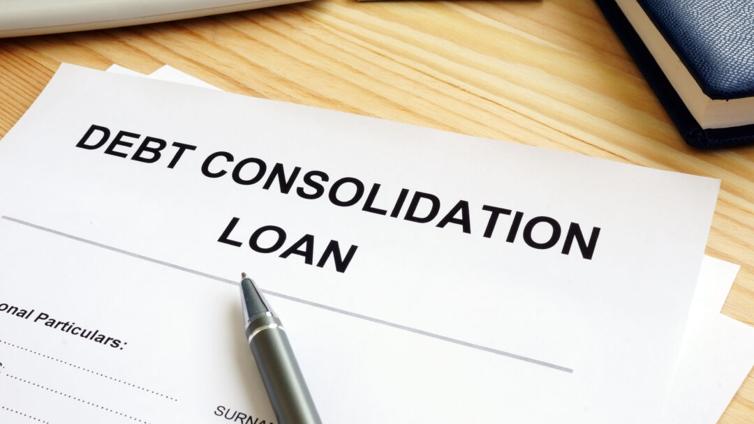 Debt consolidation loan application form on a wooden desk with a pen, calculator, and notebook nearby.